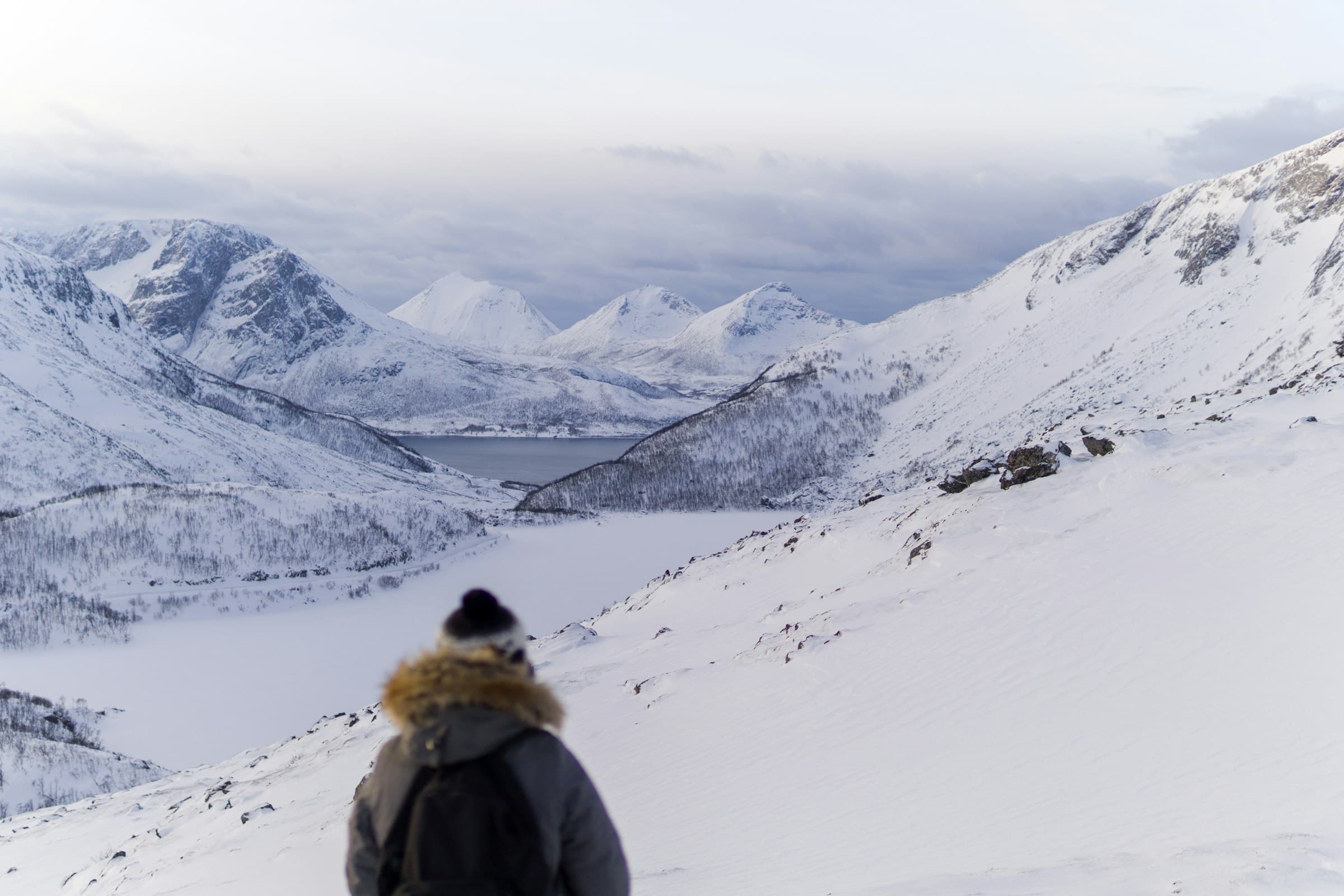 A walker in a winter coat on snowy ground
